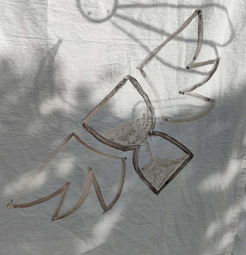Foto von einer mit Erde gemalten Sanduhr mit Flügeln. Harmlose Kunst Anna Hielscher